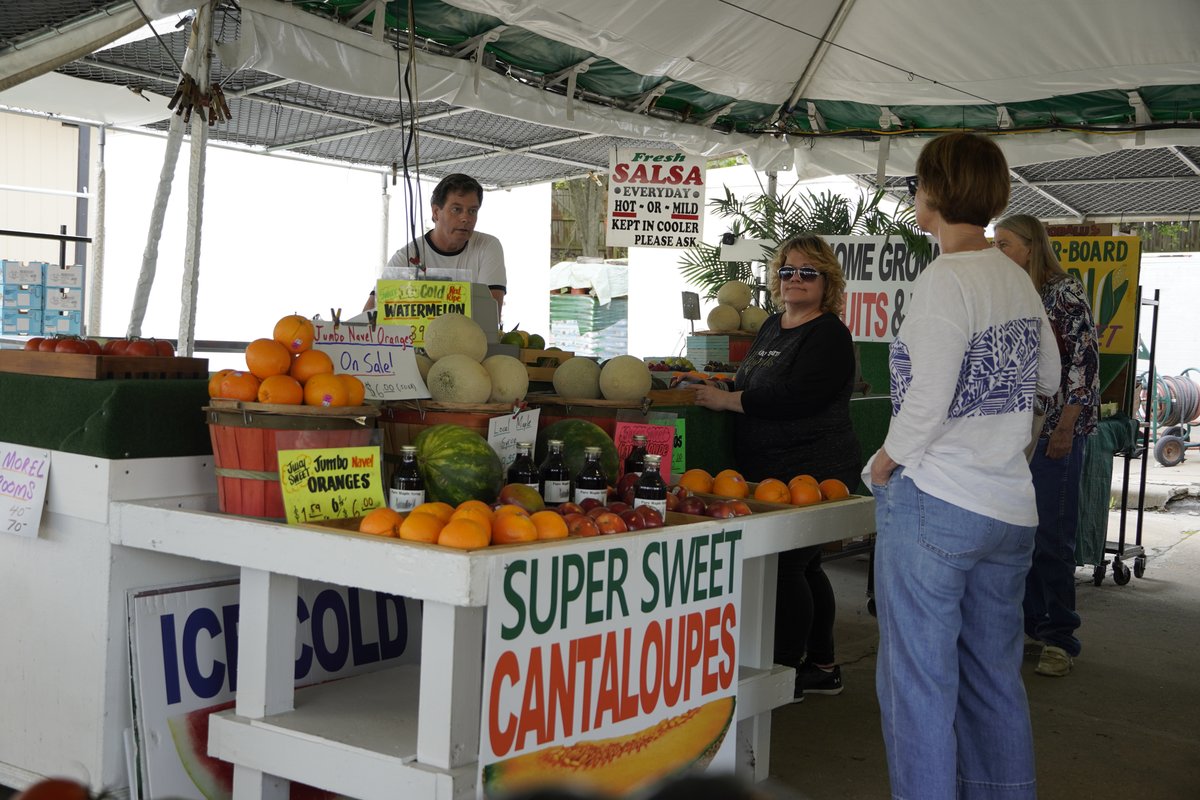 Customers shopping at Everyday Produce under the tent canopy