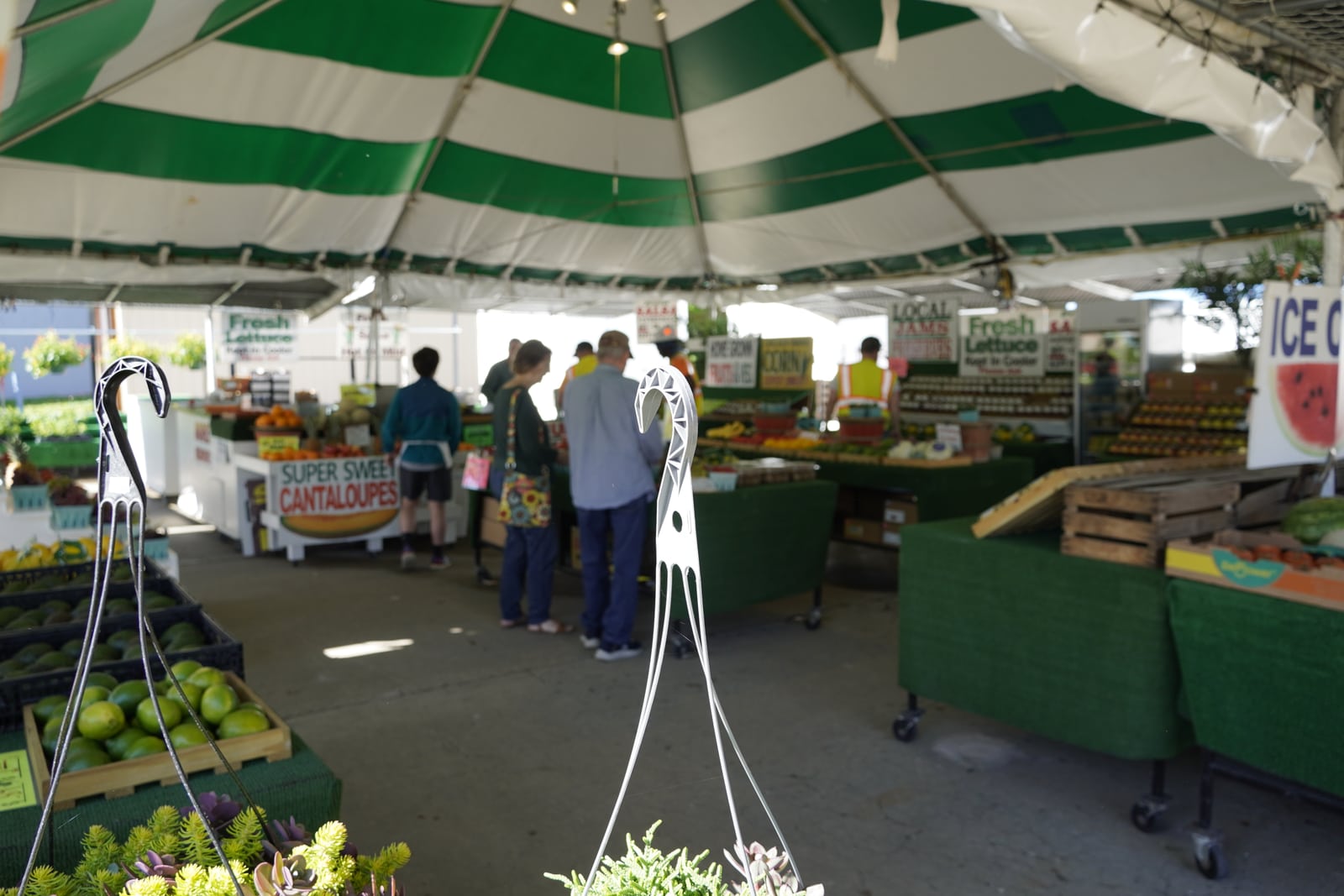 Inside the green-striped tent with customers shopping