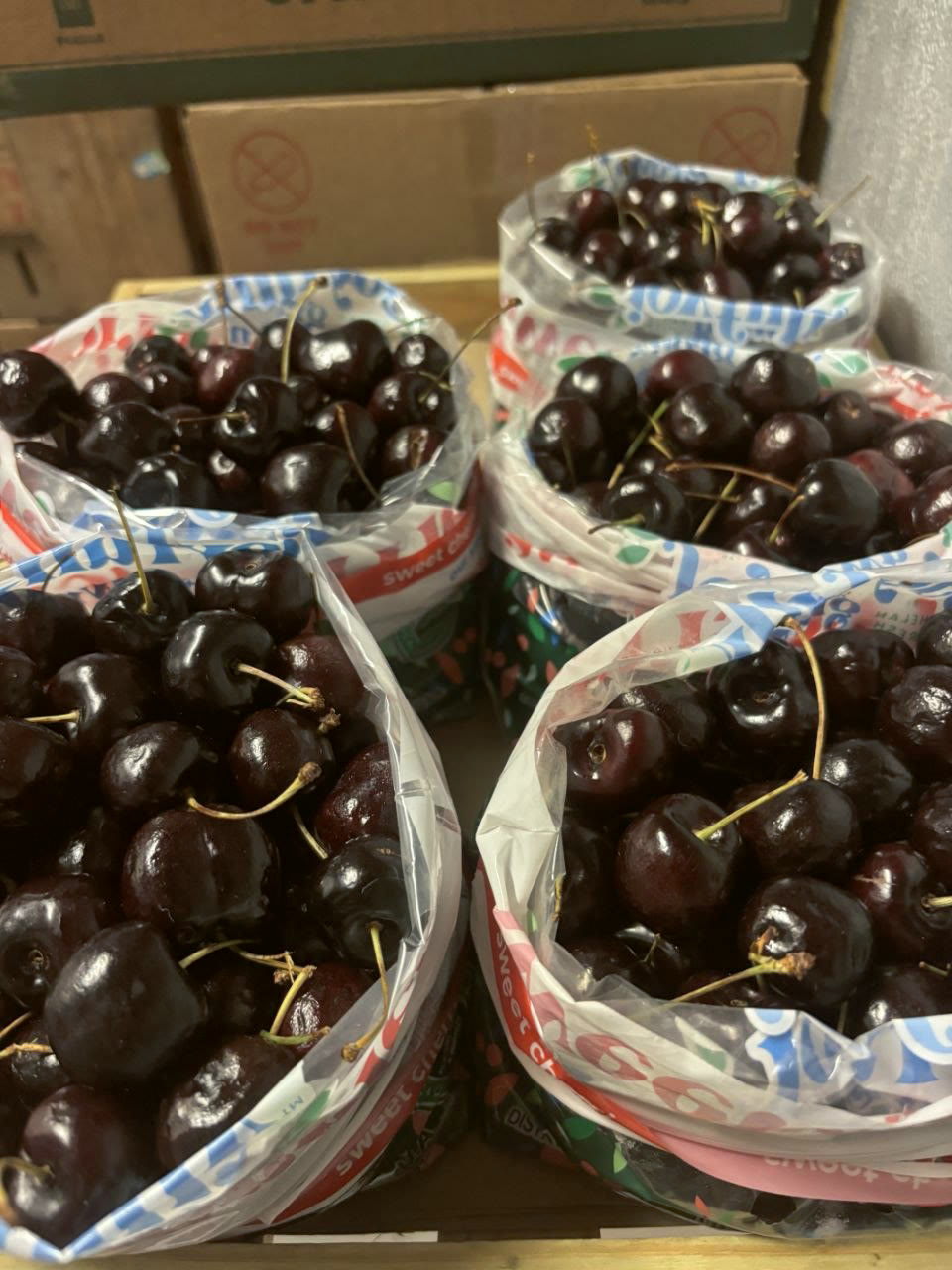 Dark sweet cherries packed into bags at the stand.